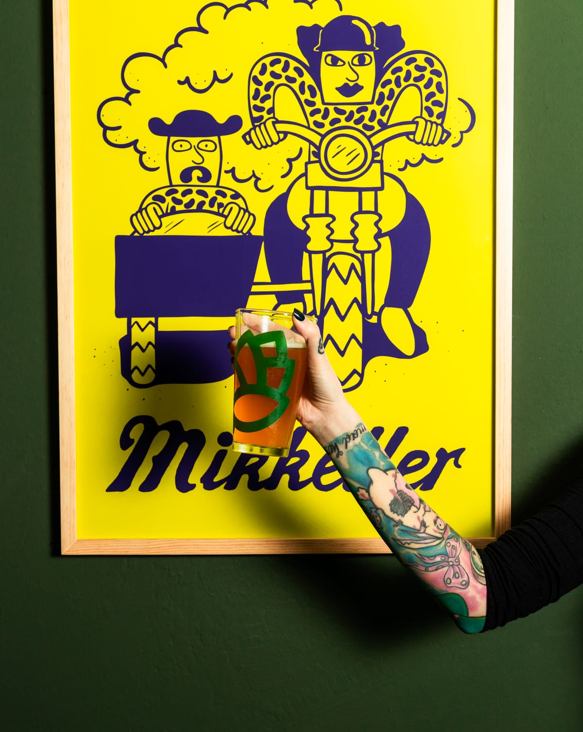 Cerveza artesanal frente a cuadros decorativos de Mikkeller en Vecindario Beer Garden