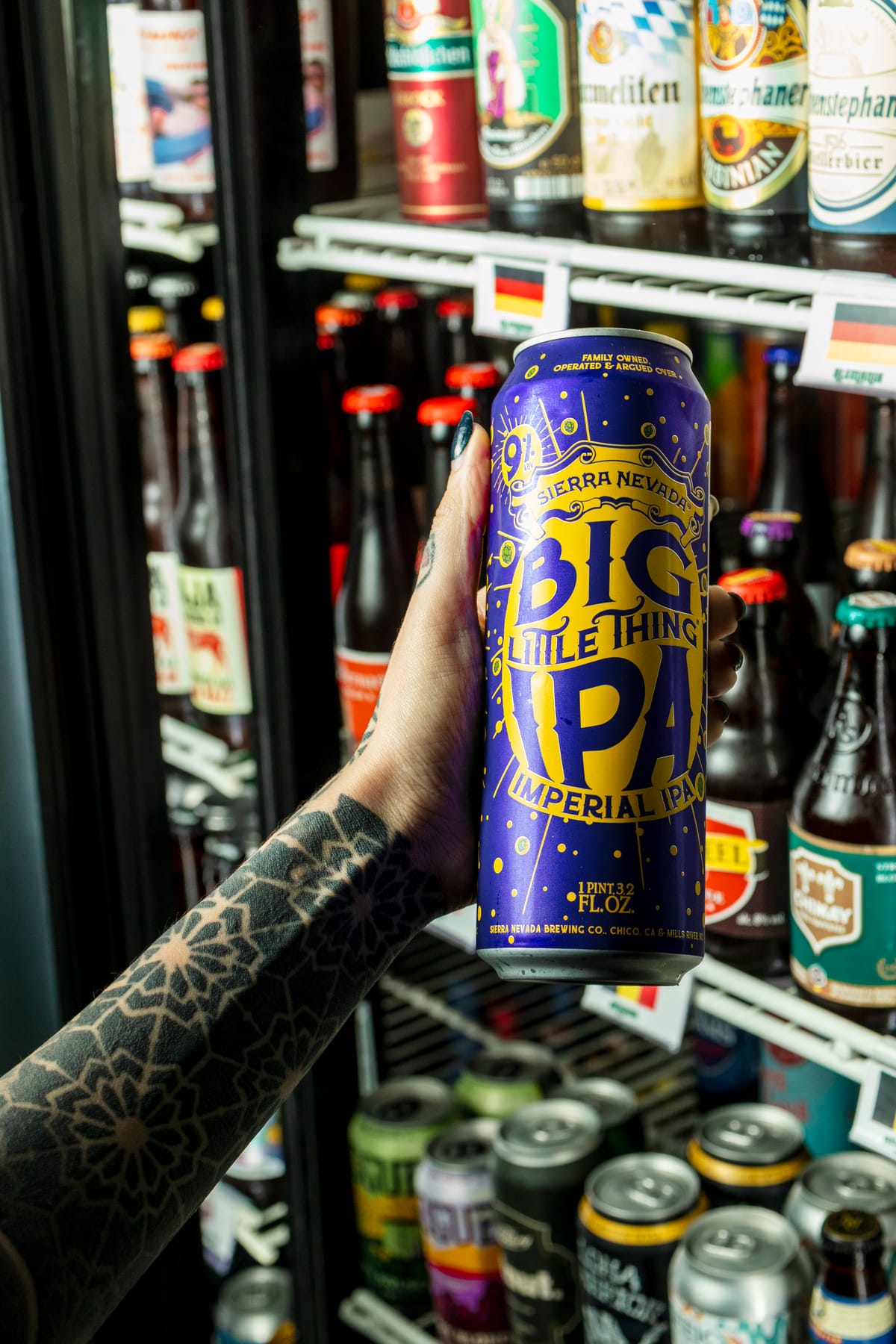 Lata de cerveza artesanal frente a la vitrina de Vecindario Beer Garden